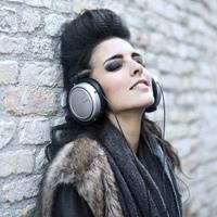 informal-young-woman-listening-to-music-near-grunge-wall-3771823